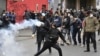 Un hombre lanza un cilindro de gas lacrimógeno durante choques entre la policía y cocaleros en La Paz, Bolivia, el 8 de agosto de 2022. Foto AFP.