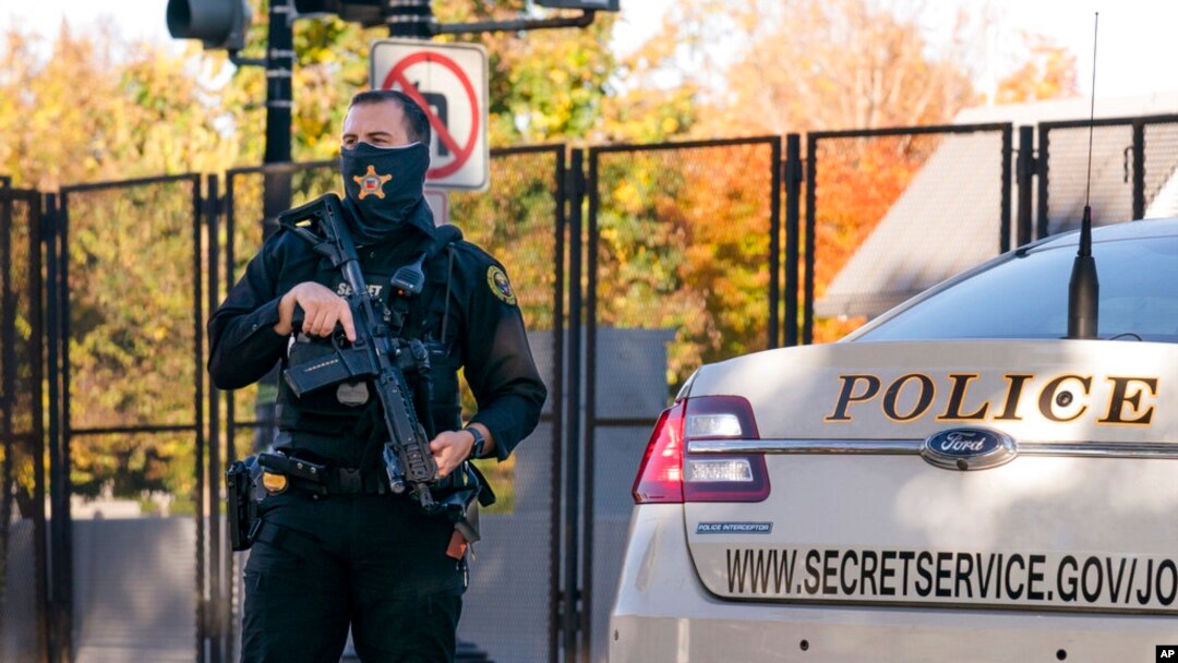 FILE - A US Secret Service officer stands guard as President Donald Trump's motorcade arrives at the White House after golfing at his Trump National Golf Club in Sterling, Virginia, Nov. 8, 2020, a day after he was defeated by President-elect Joe Biden.