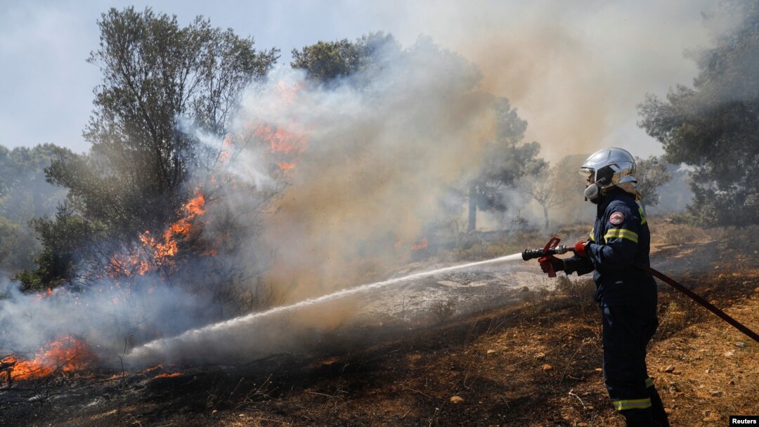 A firefighter works to extinguish a wildfire burning in Pallini, near Athens, Greece, July 20, 2022. 