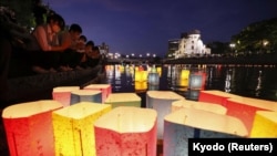 People release paper lanterns on the Motoyasu River facing the gutted Atomic Bomb Dome in remembrance of atomic bomb victims on the 77th anniversary of the bombing, in Hiroshima, Japan, on August 6, 2022, in this photo taken by Kyodo. 