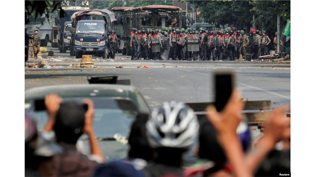 FILE - Police stand on a road during an anti-coup protest in Mandalay, Myanmar, March 3, 2021.