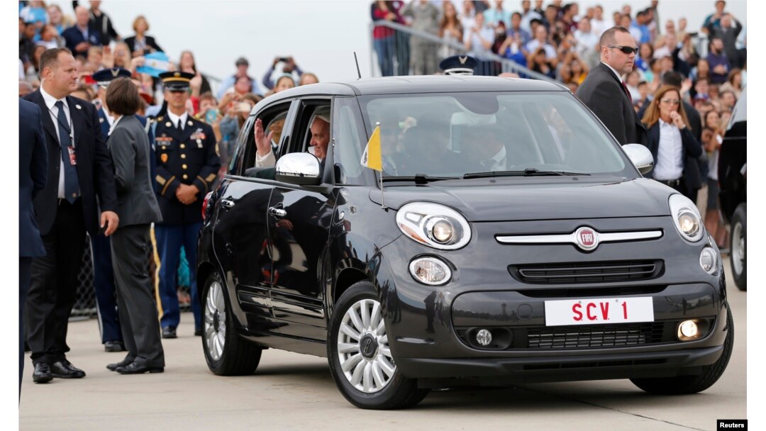 Pope Francis waves from a Fiat 500 model after being driven from Joint Base Andrews outside Washington, Sept. 22, 2015.