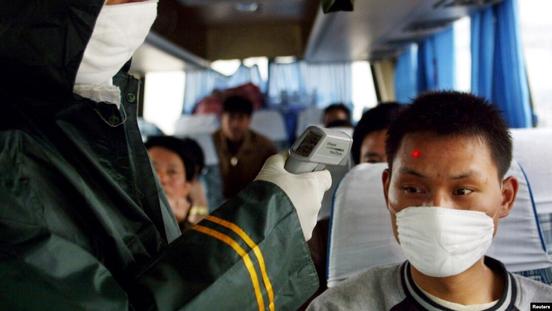 지난 2003년 중국 중부 후베이성 우한의 검문소에서 의료 관계자가 버스 승객의 체온을 확인하고 있다. (자료사진)