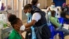 FILE - A professional paramedic receives a dose of Johnson & Johnson COVID-19 vaccine from a health staff member at a vaccination center at Chris Hani Baragwanath Academic Hospital in Johannesburg, South Africa, March 26, 2021.