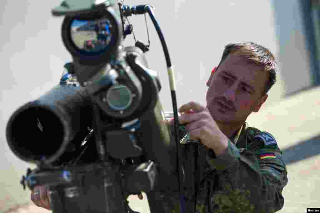 A soldier demonstrates using a Milan anti-tank rocket launcher that is part of a German military aid shipment for Kurdish forces in Northern Iraq at a storage facility of the Bundeswehr armed forces in Waren, north of Berlin, Sept. 18, 2014.
