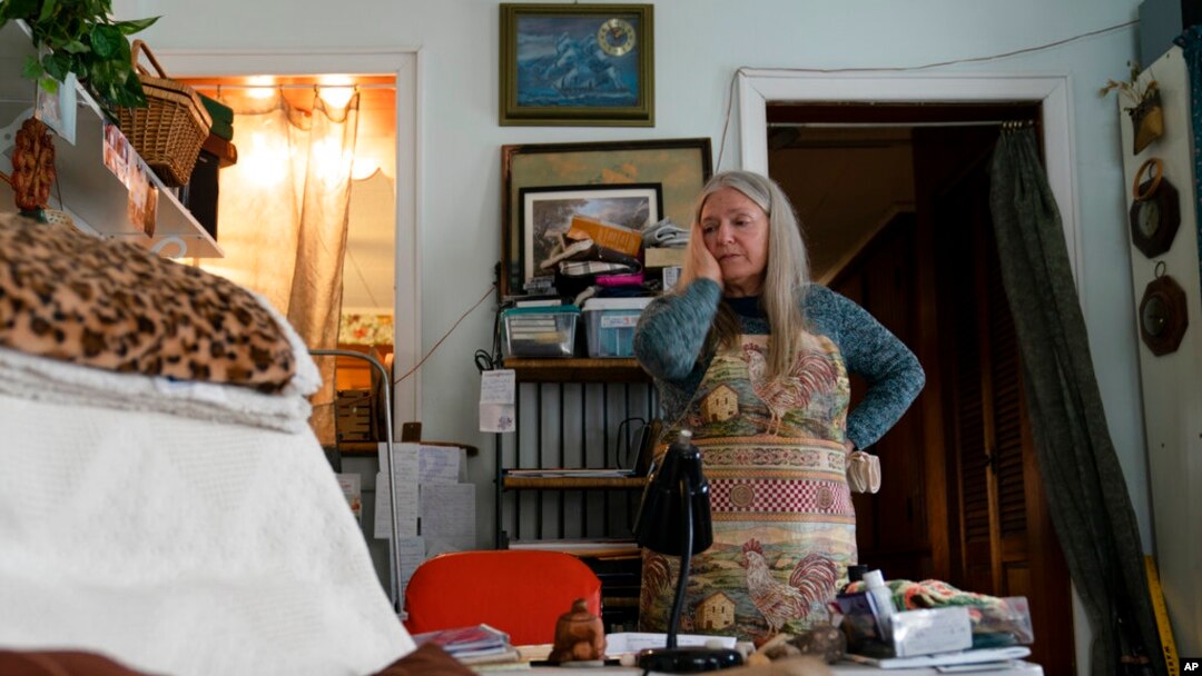 FILE - Nancy Rose, who contracted COVID-19 in 2021 and was continuing to exhibit long-haul symptoms, pauses while organizing her desk space, Jan. 25, 2022, in Port Jefferson, N.Y. Rose, 67, reported bouts of fatigue, brain fog and memory loss.