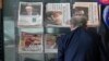 A customer looks at front pages of newspapers on display at a newsstand in London, July 8, 2022.