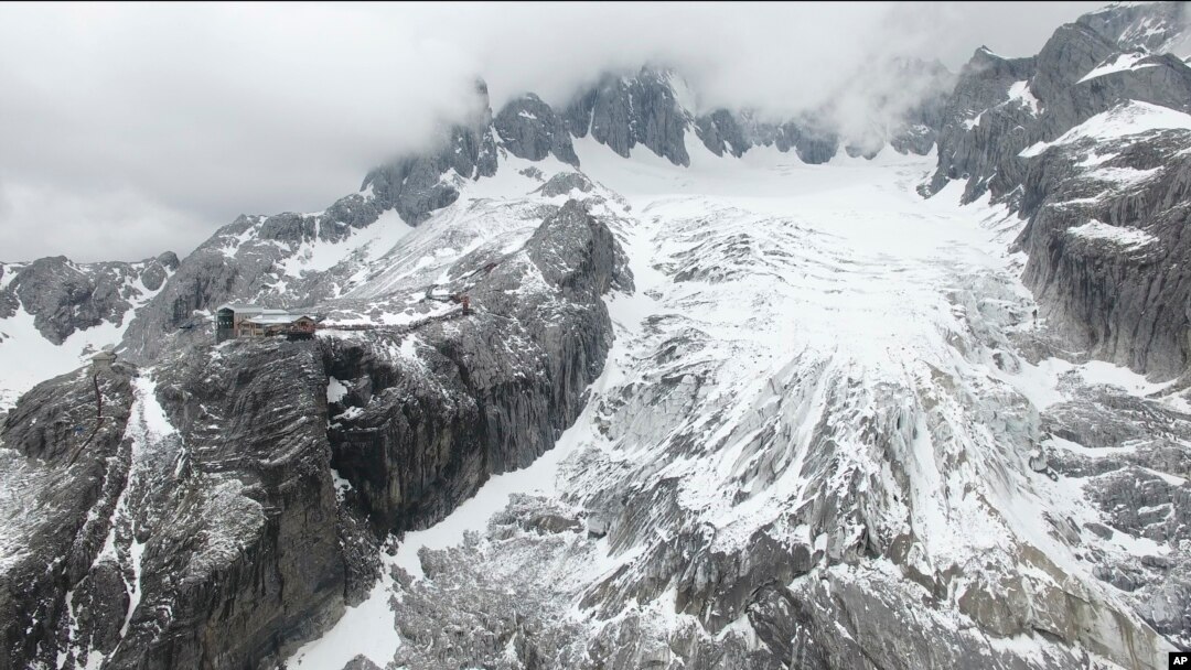 In this photo taken May 2018 and released by Yulong Snow Mountain Glacier and Environmental Observation Research Station on Oct. 18, 2018, the Baishui Glacier No.1 is visible next to a tourist viewing platform high in the Jade Dragon Snow Mountain in the 