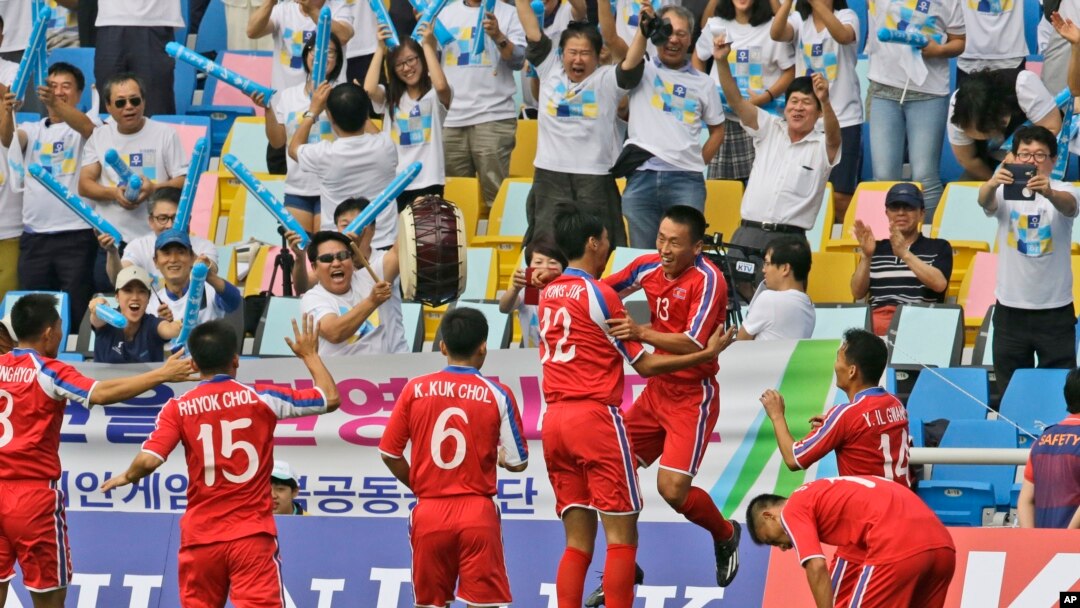 인천 아시안게임에 출전한 북한 남자 축구 대표팀 선수들이 중국과의 첫 경기에서 득점을 올린 후 환호하고 있다. 뒷쪽으로 이들을 응원하는 한국 응원단의 모습이 보인다. 북한은 중국에 3:0으로 완승을 거뒀다.