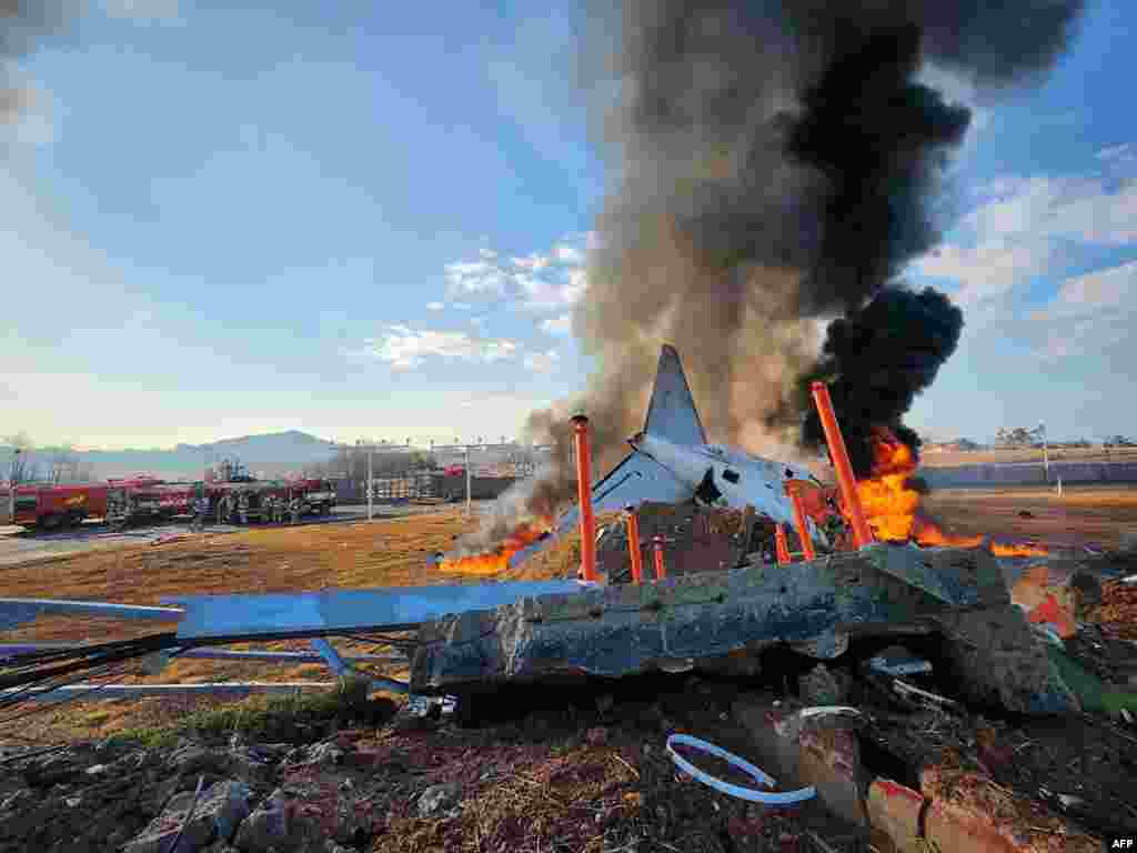 Fire and smoke rise from the tail section of a Jeju Air Boeing 737-800 series aircraft after the plane crashed and burst into flames at Muan International Airport in South Jeolla Province, some 288 kilometers southwest of Seoul, Dec. 29, 2024.