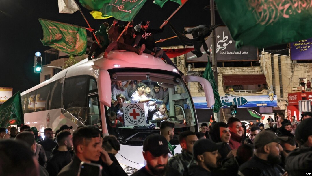Una multitud rodea a un autobús de la Cruz Roja con prisioneros palestinos liberados por Israel en Ramalah, Cisjordania, el 26 de noviembre de 2023.