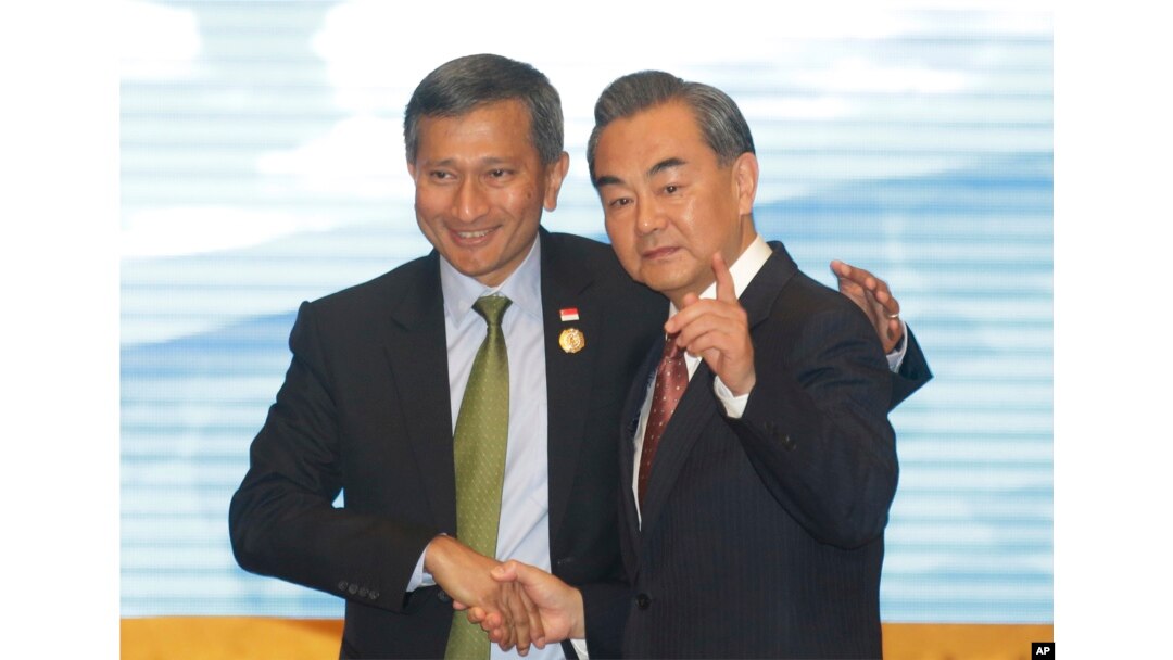 FILE - Singapore's Foreign Minister Vivian Balakrishnan, left, shakes hands with Chinese Foreign Minister Wang Yi, right before they pose for a photo during the ASEAN – China Foreign Ministers' Meeting in Vientiane, Laos, July 25, 2016.