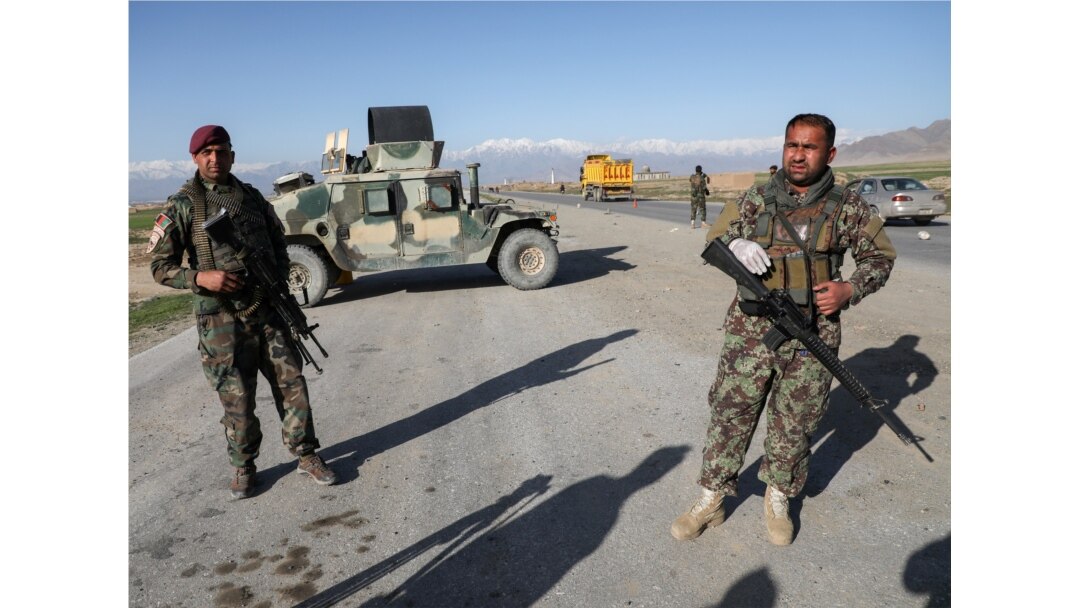 FILE - Afghan National Army soldiers stand guard at a checkpoint near the Bagram Airbase north of Kabul, Afghanistan, April 2, 2020. Battlefield violence between pro-Afghan government forces and the Taliban insurgency has surged since May 1, 2021.