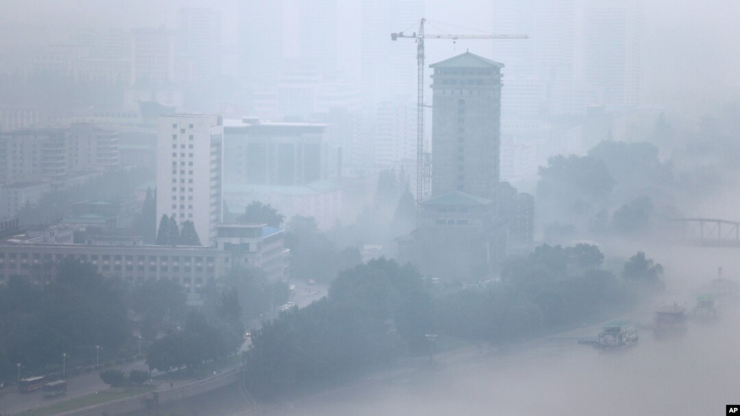 The city skyline is shrouded by a layer of mist after a torrential rain in Pyongyang, July 22, 2013.