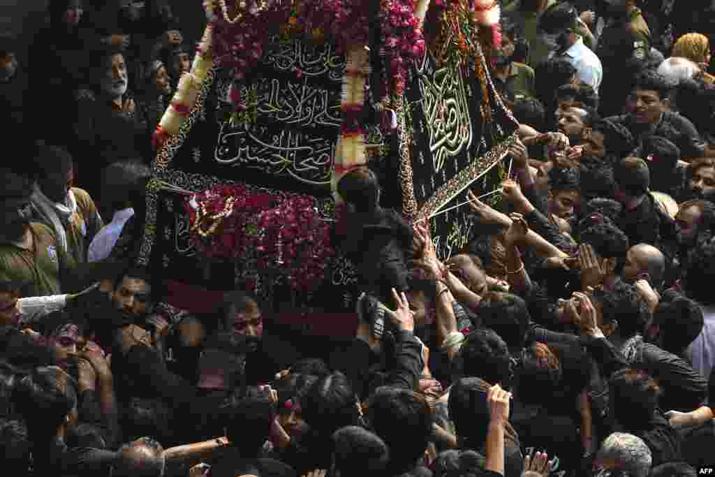 Shi'ite Muslim devotees take part in a religious procession to mark the 40th day of mourning after the death anniversary of Imam Hussain, the grandson of the Prophet Mohammed, in Lahore, Pakistan.