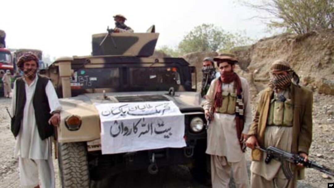 Armed militants of Tehreek-e-Taliban Pakistan (TTP) pose for photographs next to a captured armored vehicle in the Pakistan-Afghanistan border town of Landikotal on November 10, 2008, after they hijacked supply trucks bound for Afghanistan.