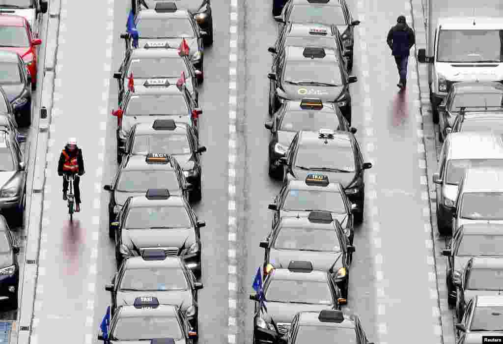Taxi drivers line a street during a protest against the online ride-sharing company Uber, in central Brussels, Belgium.