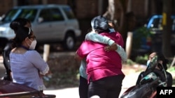 Familiares y amigos se abrazan mientras esperan los restos del periodista hondureño asesinado Luis Almendares, frente a la sede de la Junta de Medicina Forense en Comayagua, Honduras, el 28 de septiembre de 2020. 