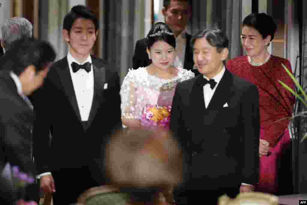 Japan's former princess Ayako Moriya (C) and her husband Kei Moriya (2nd L) arrive at their wedding banquet in Tokyo, with Crown Prince Naruhito (2nd R) and Crown Princess Masako (R) as Prime Minister Shinzo Abe bows.