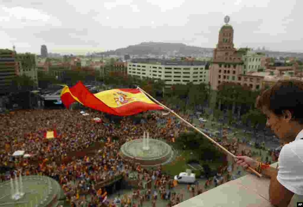 A boy waves a Spanish flag during Spain's National Day celebrations in the Catalan city of Barcelona, Spain.