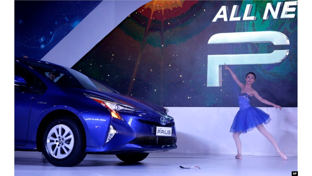 A performer dances as Toyota's 4th generation Prius Hybrid car is launched at the Auto Expo in Greater Noida, near New Delhi, India, Feb. 4, 2016.
