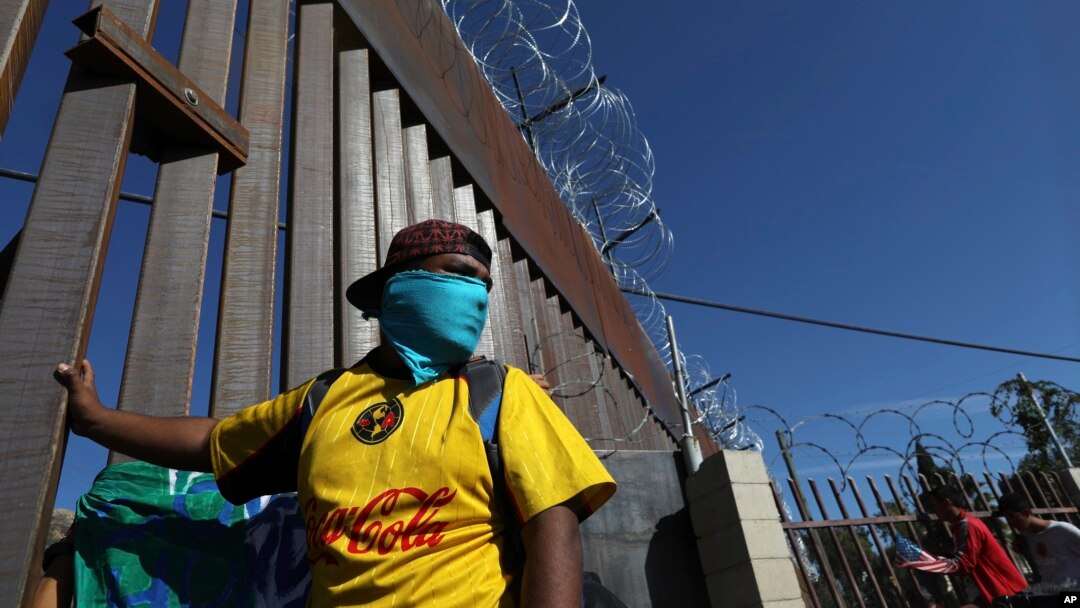 Migrants gather at the Mexico-U.S. border after getting past a line of Mexican police at the Chaparral crossing in Tijuana, Mexico, Nov. 25, 2018, as they try to reach the U.S. 