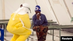 FILE - A health worker wearing protective gear attends to a newly admitted suspected Ebola patient in a quarantine zone at a Red Cross facility in Koidu, Kono district, Sierra Leone, Dec. 19, 2014. 