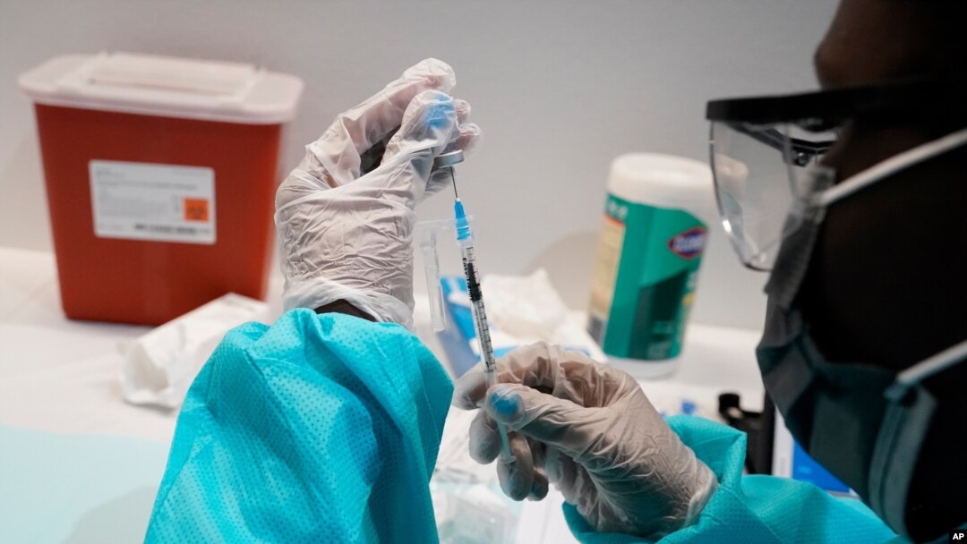 A health care worker fills a syringe with the Pfizer COVID-19 vaccine at the American Museum of Natural History in New York, July 22, 2021. 