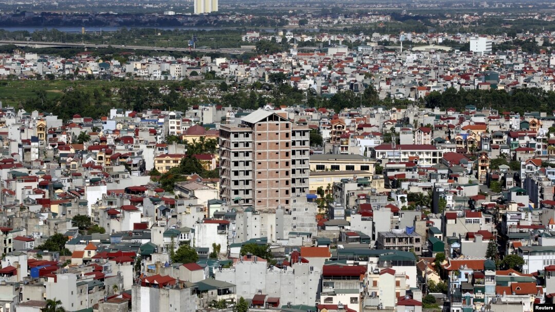 FILE - An apartment building under construction (C) is seen surrounded by older residential houses in Hanoi July 1, 2015.