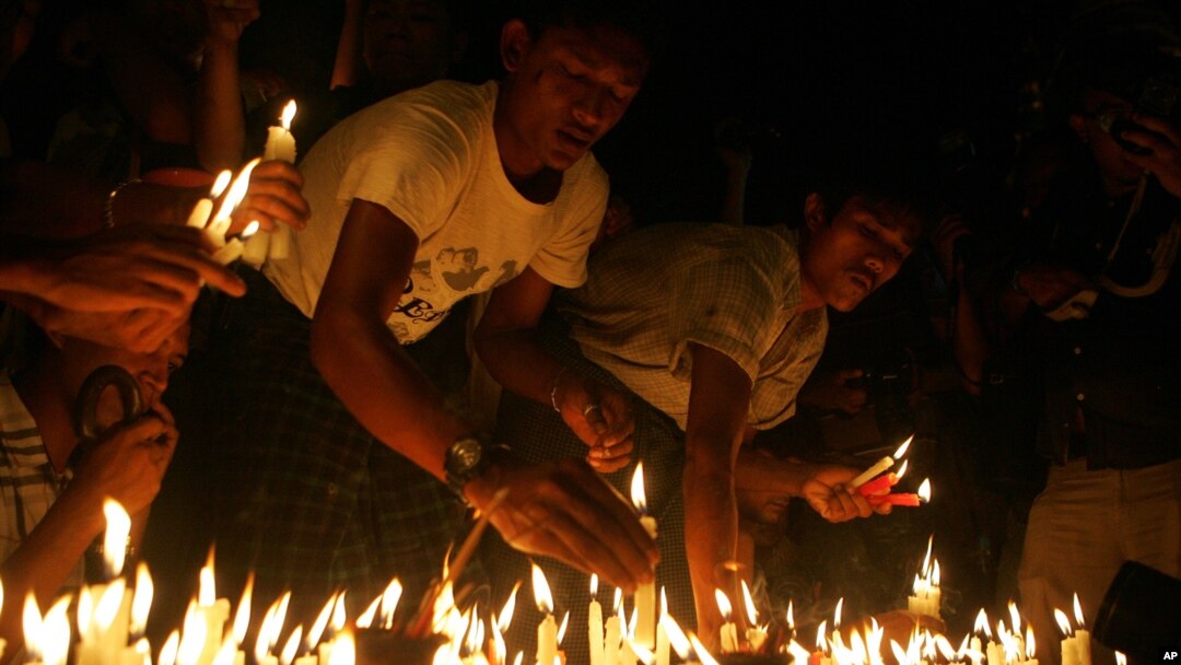 Protesters hold candles during a candlelight vigil at Sule Pagoda in Rangoon, Burma, May 23, 2012. 