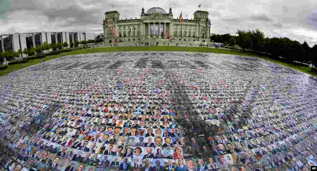 Portraits of politicans are placed in front of the Reichstag building, host of the German federal parliament Bundestag, by the '#unverhandelbar' (#non-negotiable) campaign group in Berlin, Germany, to protest against human rights at Europe's external borders.