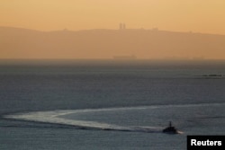 FILE - An Israeli naval vessel sails in the Mediterranean sea near the border with Lebanon, as Mount Carmel and the Israeli city of Haifa are seen in the background, Dec. 16, 2013.