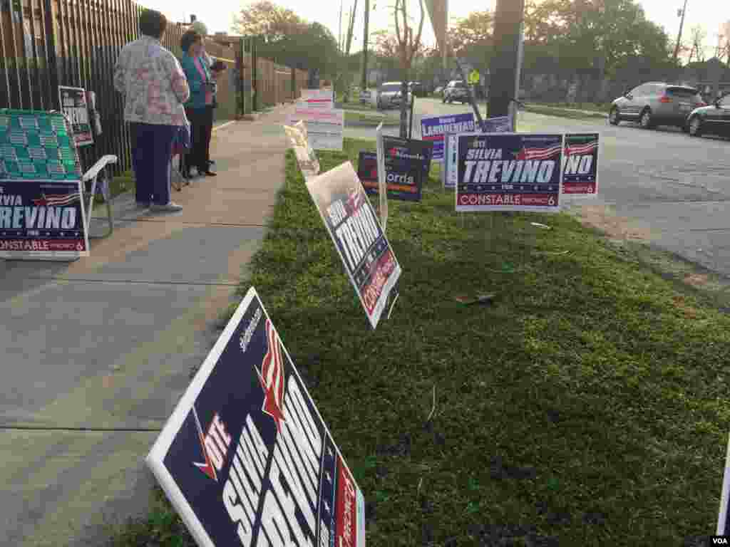 Campaign posters are seen on a pathway to a polling station in Harris County, Houston, Texas, March 1, 2016. (G. Tobias / VOA)