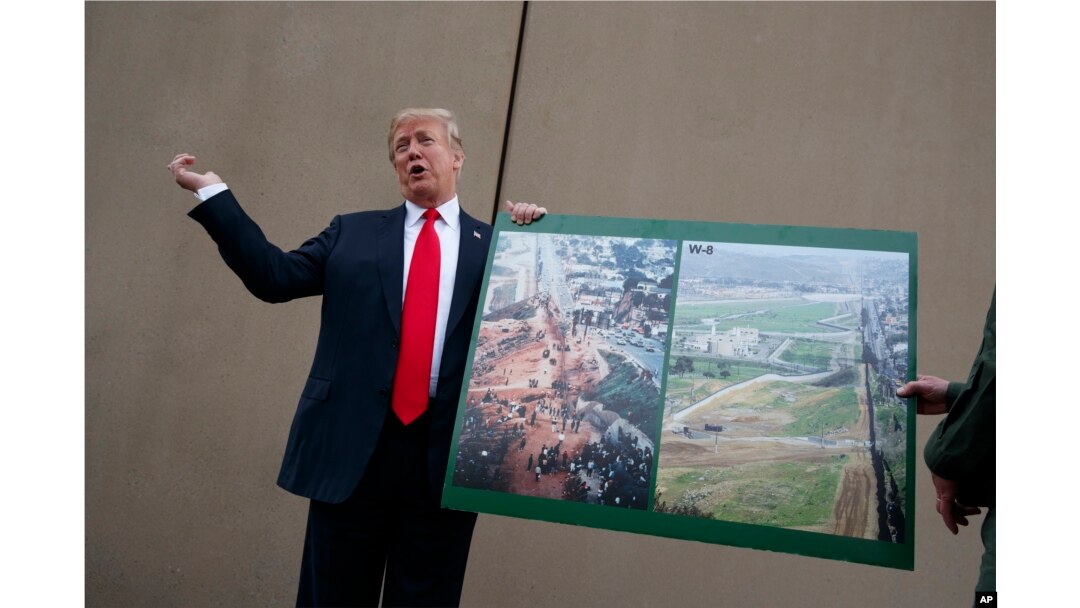 FILE - President Donald Trump talks with reporters as he gets a briefing on border wall prototypes, in San Diego, California March 13, 2018.