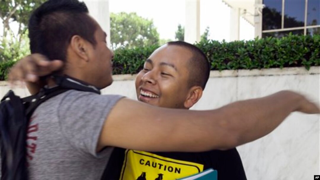 Students Irvis Orozco, left, and Jorge Gutierrez hug outside the US Citizenship and Immigration Services at the Federal Building in Los Angeles Wednesday, Aug. 15, 2012.