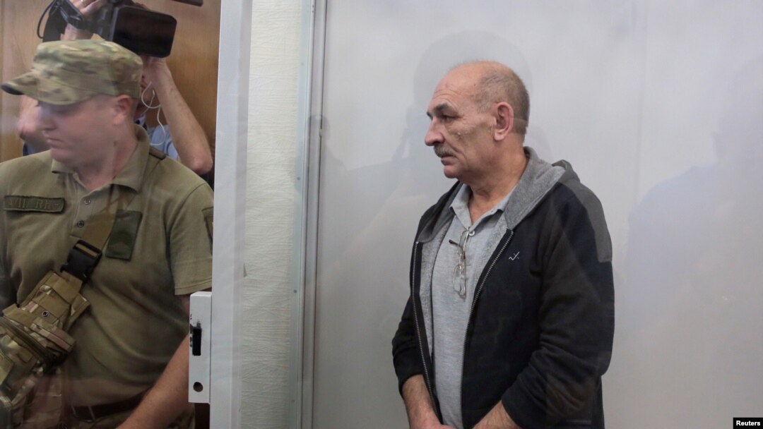 Volodymyr Tsemakh, suspected of involvement in the downing of the Malaysia Airlines Flight MH17 plane in 2014, stands inside a defendants' cage during a court hearing in Kyiv, Ukraine, Sept. 5, 2019. 