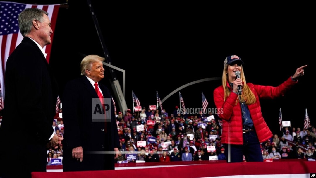 FILE - In this Dec. 5, 2020, file photo Georgia Senator Kelly Loeffler speaks as President Donald Trump and Georgia Senator David Perdue listen at a campaign rally at Valdosta Regional Airport, Dec. 5, 2020, in Valdosta, Georgia.