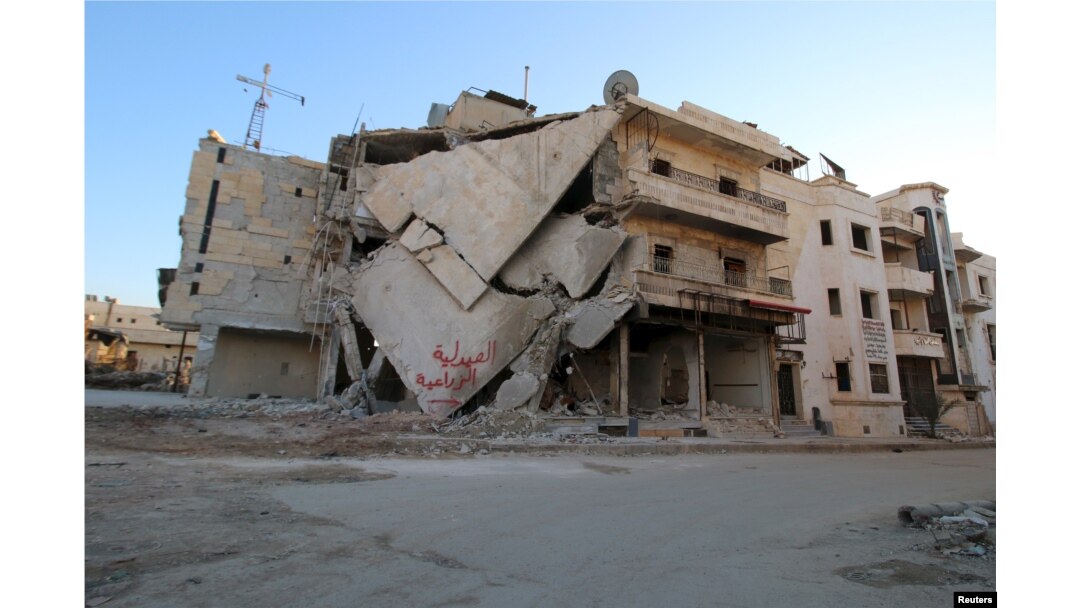 A damaged building is seen in Hraytan city, about 10 kilometers away from the towns of Nubul and Zahraa, Northern Aleppo countryside, Syria, Feb. 3, 2016. The text on the building reads in Arabic: "Agricultural pharmacy."