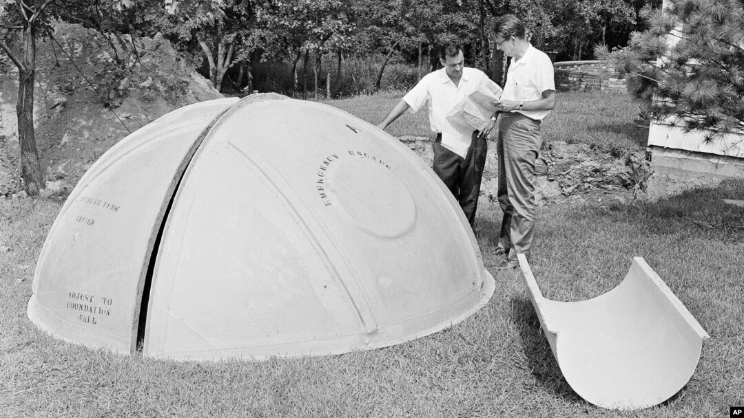 FILE - Bomb shelter manufacturer engineers Vincent Carubia, left, and Eward Klein study specifications for a fiber glass dome shelter being installed on an estate in Locust Valley, N.Y., Sept. 7, 1961.
