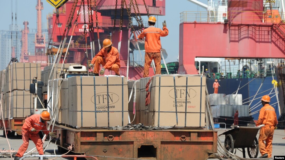 FILE - Workers load goods for export onto a crane at a port in Lianyungang, Jiangsu province, China, June 7, 2019. 