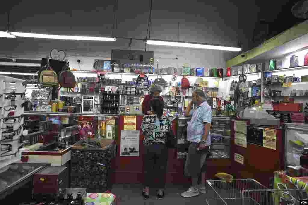 Cubanos que llegan de visita a Miami, donde vive la mayor parte de exiliados de la isla en Estados Unidos, pasan por la tienda que recuerda a mercados similares que funcionaron en Cuba en años de menos escasez tras la revolución de 1959.