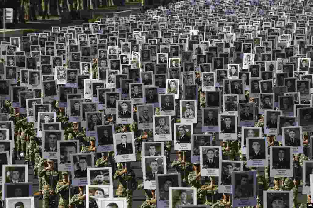 Azerbaijan's Army soldiers carry portraits of the soldiers killed during the fighting over Nagorno-Karabakh in 2020, during a memorial event in Baku, Azerbaijan.