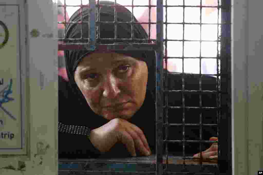 A Palestinian woman waits to receive food aid at a United Nations distribution center in the Shati refugee camp in Gaza City, Aug. 6, 2014.