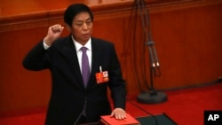新當選的中國人大委員長栗戰書2018年3月17日在全國人大全體會議上手按憲法，宣誓就職。