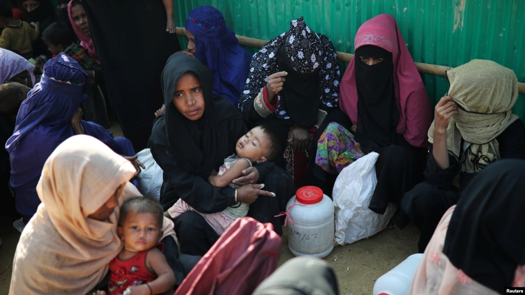 Rohingya refugee women wait outside of a medical center at Jamtoli camp in Cox's Bazar, Bangladesh, Jan. 22, 2018.