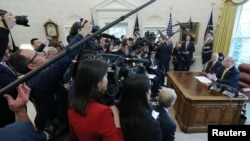 Surrounded by the press, President Donald Trump speaks while meeting with China's Vice Premier Liu He in the Oval Office of the White House in Washington, April 4, 2019.