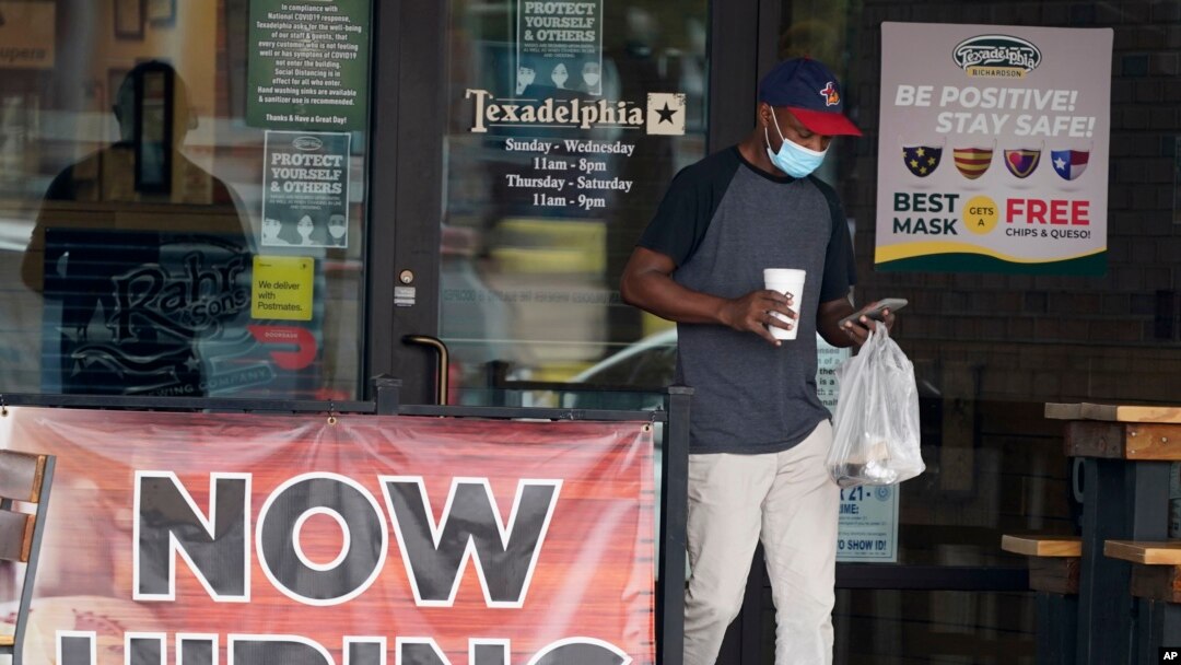 A customer walks past a now hiring sign at an eatery in Richardson, Texas, Sept. 2, 2020. 