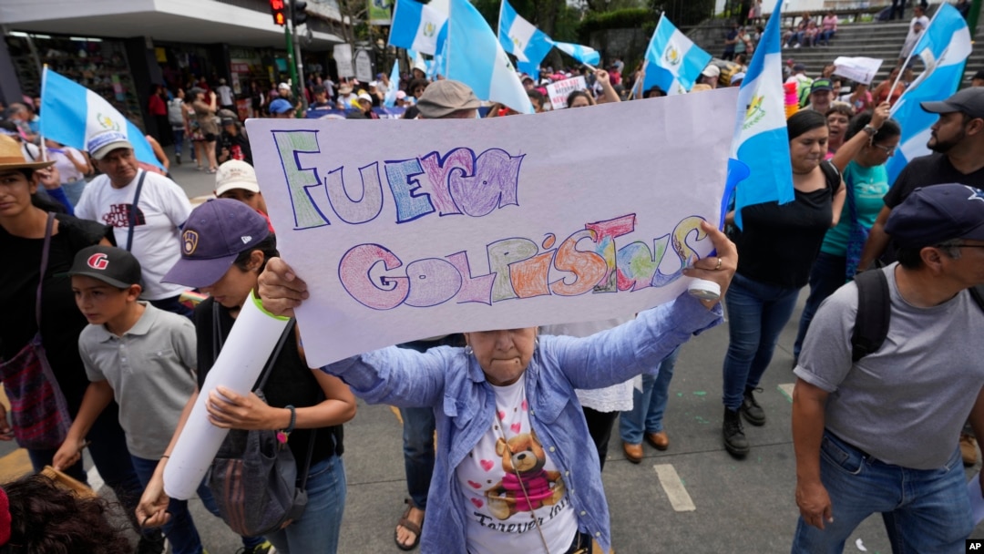 Una mujer sostiene un cartel durante una marcha contra las acciones legales emprendidas por la Fiscalía General contra el partido Movimiento Semilla y el presidente electo Bernardo Arévalo en Ciudad de Guatemala, el 2 de septiembre de 2023.