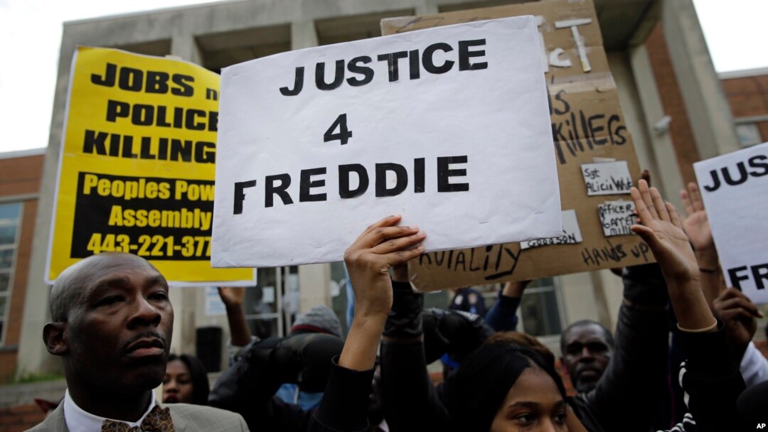 FILE - Protestors stand outside of the Baltimore Police Department's Western District police station during a march and vigil for Freddie Gray, April 21, 2015.