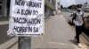 FILE - A man walks past newspaper billboards during the coronavirus disease (COVID-19) outbreak in Johannesburg, South Africa, Feb. 8, 2021.